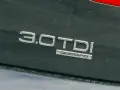 Napis "3.0 TDI quattro" na ciemnym lakierze. Ta pojemność silnika sugeruje moc i osiągi.