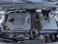 Silnik samochodu hybrydowego z widocznymi elementami układu chłodzenia, akumulatora i skrzynki filtrów powietrza.