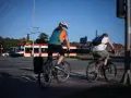 Rowerzyści jadący wzdłuż torów tramwajowych, w tle czerwono-biały tramwaj. Trasa rowerowa wiodąca w kierunku Westerplatte.