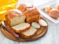 Zwiebelbrot rezept: goldbraune Brote mit Zwiebeln, angeschnitten, daneben Zwiebeln und ein Messer.