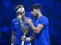 Carlos Alcaraz y Casper Ruud, dos tenistas en un momento de concentración, con raquetas y pelota.