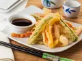 Crujiente tempura de verduras, con zanahoria, calabacín y pimiento, servida con salsa de soja.