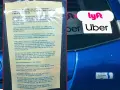 Naklejki Lyft i Uber na tylnej szybie samochodu, obok zasad jazdy.
