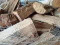 Un tas de bois sec, prêt à crépiter dans la cheminée. Les bûches sont emballées dans un filet blanc.