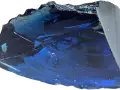Fragmento de obsidiana azul con reflejos profundos y texturas irregulares, como un trozo de cielo nocturno solidificado.