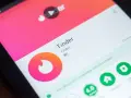 Ekran tabletu z aplikacją Tinder, gdzie szukasz idealnych **tinder pary**. Widoczne logo i nazwa aplikacji.