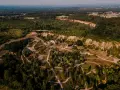 Widok z lotu ptaka na krajobraz z lasami, drogą i budynkami. W oddali widać miasto. To miejsce przypomina ptasią rzeczpospolitą, gdzie natura i cywilizacja współistnieją.