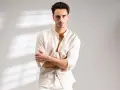 Uomo con outfit bianco e nero, camicia lino con colletto alla coreana e pantaloni chiari.