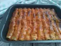 Cannelloni di carne ricetta della nonna, cotti al forno e ricoperti di sugo rosso e formaggio fuso.