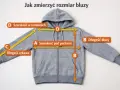 Szara bluza z kapturem z miarką, pokazująca wymiary: szerokość w ramionach, pod pachami, długość rękawa i bluzy.