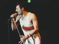 Freddie Mercury, jeden z najlepsi muzycy wszechczasów, śpiewa do mikrofonu na koncercie.