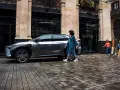 Rodzina spaceruje obok ładowanego samochodu elektrycznego w trybie ev mode.