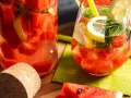 Orzeźwiający drink w arbuzie z cytryną i miętą, podany w szklance i karafce. Idealny na upalne dni.
