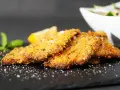 Cotoletta alla palermitana dorata e croccante, guarnita con limone e menta.