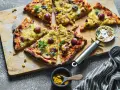 Domowa pizza z kurczakiem, kukurydzą i czerwoną cebulą, pokrojona na kawałki, gotowa do podania.