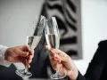 Dwie osoby wznoszą toast kieliszkami szampana. To z pewnością wesoła 25 rocznica ślubu!