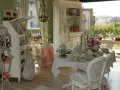 Un tavolo apparecchiato in **stile provenzale francese**, con sedie bianche, candelabri e fiori rosa.