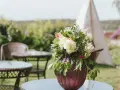 Un hermoso arreglo de flores en un jarrón morado, perfecto para celebrar un feliz día del Carmen.