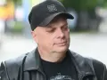 Krzysztof Skiba w czarnej czapce z napisem "BRK LYN" i skórzanej kurtce, zamyślony.