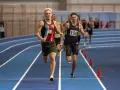 Filip Ostrowski biegnie w zawodach lekkoatletycznych. Dwóch zawodników na pierwszym planie, jeden z numerem 48, drugi z 156.