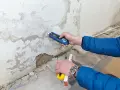 Feuchtemessung an einer Wand. Die isotec kosten pro qm hängen vom Ausmaß des Schadens ab.