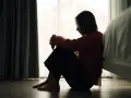 Ein Mädchen sitzt traurig auf dem Boden, die Knie angezogen. Die Szene könnte die emotionale Achterbahnfahrt bei borderline bei Kindern darstellen.