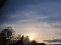 Sonnenuntergang mit zarten Wolken, die wie Pinselstriche wirken. Bäume im Vordergrund, die an Psalm 147,3 erinnern: "Er heilt, die zerbrochenen Herzens sind, und verbindet ihre Wunden.