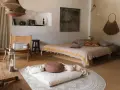 Ein gemütlicher Raum zum Meditieren einrichten: Ein Bett, ein Stuhl, Kissen und Decken laden zur Entspannung ein.