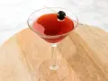 Czerwony drink w kieliszku koktajlowym, ozdobiony oliwką na wykałaczce. Idealny drink San Francisco na letnie wieczory.