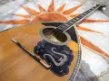 Piękny grecki instrument muzyczny, bouzouki, leży na mozaice z symbolem słońca.