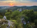 Zachód słońca nad Górami Świętokrzyskimi. Skaliste formacje i bujna zieleń tworzą malownicze krajobrazy, jedne z wielu atrakcji regionu.