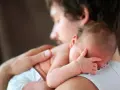 Padre abbraccia neonato. Osservare attentamente i sintomi autismo nel neonato di 3 mesi, come la mancanza di contatto visivo o risposte emotive atipiche.