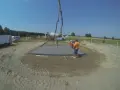 Pierwszy etap budowy domu krok po kroku: wylewanie fundamentów. Beton z gruszki płynie do szalunku.