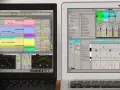 Dos ordenadores muestran software de producción musical, con pistas de audio y MIDI. Ideal para crear música sin licencia.