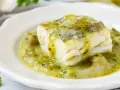 Un trozo de merluza a la vasca, jugoso y tierno, bañado en una salsa verde cremosa con trozos de pimiento.