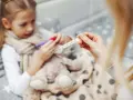 Chora dziewczynka z gorączką, mama mierzy temperaturę. Czy to rotawirus?