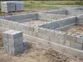 Fundament domu z pustaków betonowych. Różne rodzaje betonu i materiałów budowlanych na placu budowy.