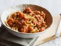 Eine Schüssel Spaghetti mit einer herzhaften, tomatigen Bolognese-Sauce, perfekt für eine schnelle Mahlzeit.