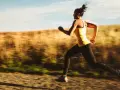 Kvinna springer i full fart, ett intensivt hiit pass utomhus.