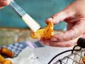 Hände putzen mit einem Pinsel sorgfältig Pfifferlinge für ein köstliches Gericht.