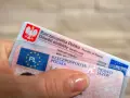 Dłoń trzyma polski dowód osobisty i prawo jazdy. To dokumenty, które pozwalają na swobodne podróżowanie, a prawo jazdy bezterminowe daje spokój na lata.