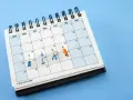 Miniaturki ludzi na kalendarzu z napisem "4-day work week". To karta nauczyciela zmian, która pokazuje, jak można zaplanować krótszy tydzień pracy.