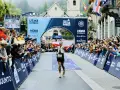 Biegacz z polską flagą przekracza metę UTMB Mont-Blanc. Tłum kibiców świętuje jego sukces.