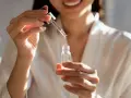 Kobieta aplikuje serum z kwasem fitynowym, dbając o swoją cerę.