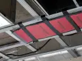 Niedbale zamontowane ogrzewanie na podczerwień "Dream Heat" pod sufitem podwieszanym. Wady instalacji widoczne gołym okiem.