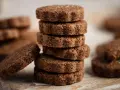 Stack of chocolate biscotti on a wooden board.