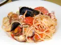 Spaghetti allo scoglio con cozze, vongole, calamari e pomodoro. Un piatto di mare ricco e saporito.