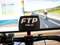 Écran d'entraînement cycliste affichant des données et une course virtuelle. Le logo FTP VELO est bien visible, prêt pour un entraînement de cycliste pro.