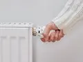 Mano girando la perilla del radiador para saber como encender la calefacción desde la caldera.