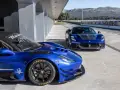 Dwa niebieskie Maserati na torze wyścigowym. Jedno z nich, z bliska, ma na oponach napis Pirelli P Zero.